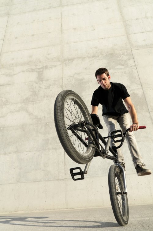 Hình ảnh Người đạp xe trẻ tuổi trên nền bê tông màu xám