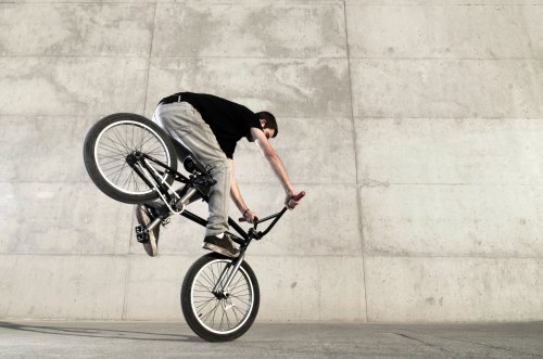 Hình ảnh Người đi xe đạp trẻ tuổi trên nền bê tông màu xám