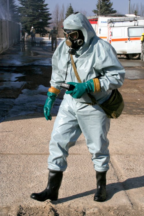 Ảnh chụp Người đàn ông trong bộ trang phục bảo hộ hóa chất, thực hiện khu vực khử nhiễm