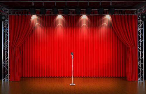 Ảnh chụp microphone cổ điển trên sân khấu Nhà hát với màn cửa màu đỏ và ánh đèn 