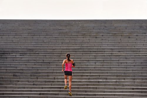 Hình ảnh người phụ nữ tập thể thao chạy lên cầu thang ngoài trời