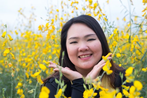 Hình ảnh phụ nữ châu Á xinh đẹp cười hạnh phúc trong vườn hoa màu vàng