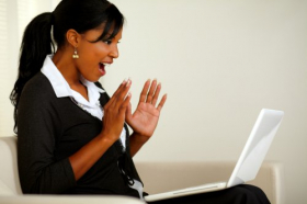 Ảnh chụp chân dung của một phụ nữ trẻ ngạc nhiên khi đọc một tin tức kinh doanh tuyệt vời trên máy tính xách tay 