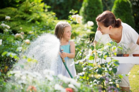 Ảnh chụp Cô gái và cô bé tưới nước trong vườn