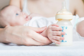 Ảnh chụp em bé giữ bình sữa chứa sữa mẹ