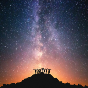 Ảnh nhóm người đang đứng trên đỉnh đồi bên cạnh thiên hà Milky Way